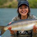 Naoko Suzuki holding a large fish on riverbank